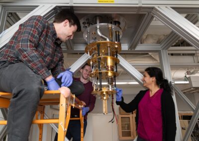 Students and Meenakshi Installing more components in the dilution fridge.